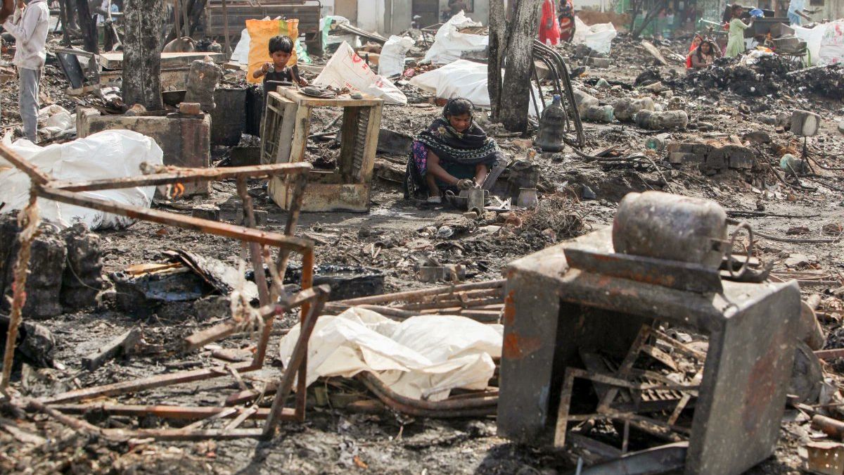 दिल्ली के अंधेरिया मोड़ स्थित नेचर बाजार में लगी भीषण आग के बाद जली हुई दुकानों और उठते धुएं का दृश्य